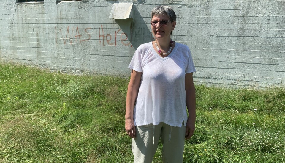TILBAKE I LEIEREN: Kati Batta Bjørnstad besøkte leiren Solsletta for første gang i voksen alder i 2021. På veggen bak henne har noen sprayet «I was here». FOTO: privat
