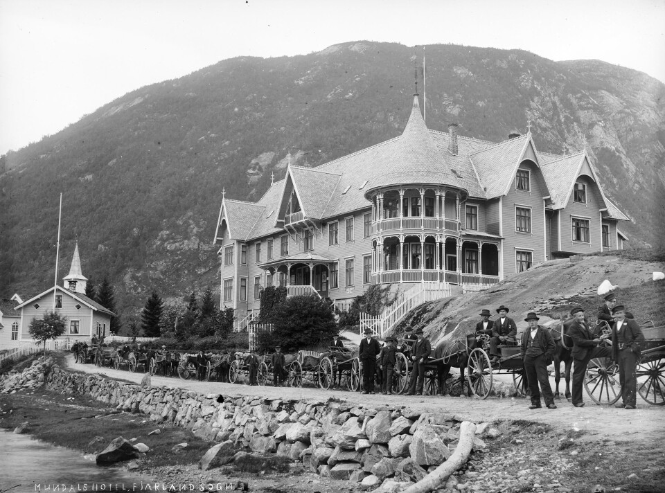 TRANSPORT AV TURISTAR: Skysskarar oppstilte framfor Hotel Mundal. Bøyabreen og Supphellebreen, hovudattraksjonane i Fjærland, ligg om lag 10 kilometer frå hotellet. Transport av turistar fram til dei to sidearmane av Jostedalsbreen skapte ei fin attåtinntekt for bøndene i bygda. Fotograf: Andreas Mathias Anderssen. Datering: 1891–1910.