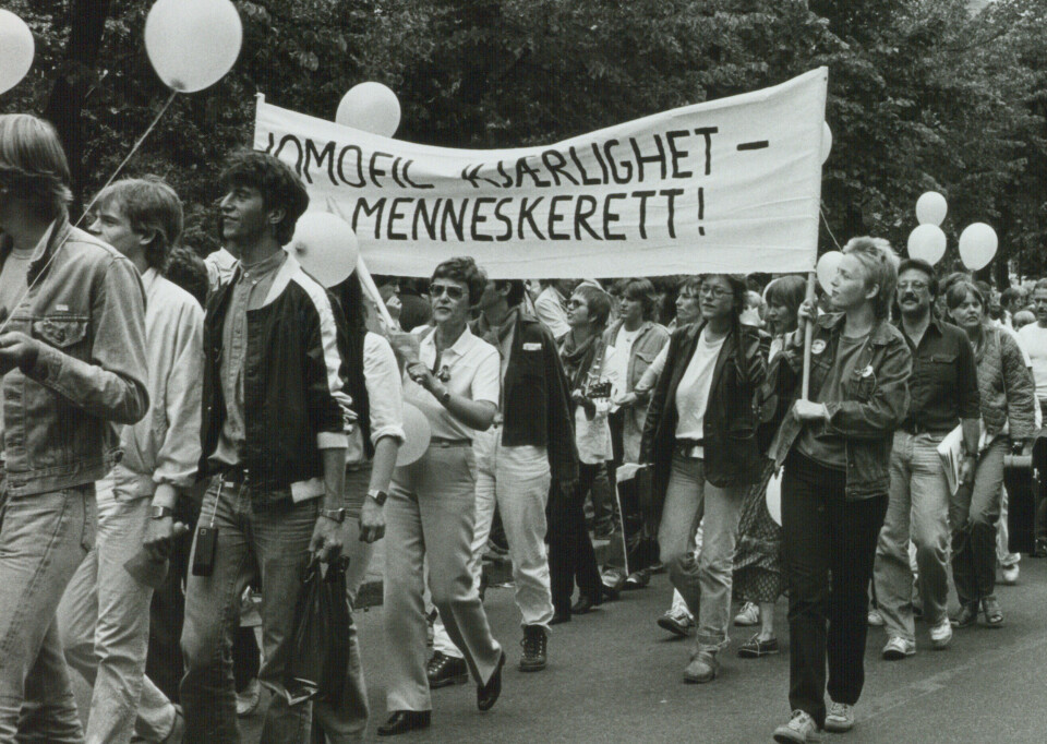 Et bilde som vister Kim Friele under Homodagene i Oslo i 1982 bærene på en fane ned teksten: homofil kjærlighet - menneskerett!
