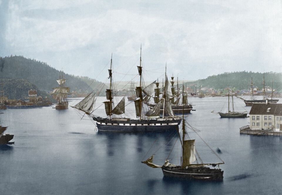 Bilde som viser Arendal havn rundt 1875 med rundt seks skip på vannet.