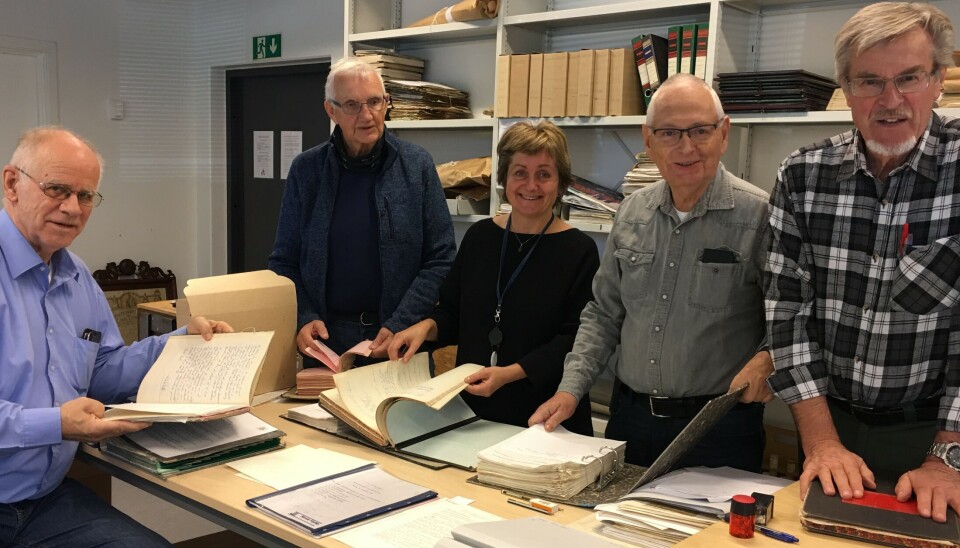 FRIVILLIGE MED EKSPERTISE: Denne gjengen var tidligere ansatt ved Jahres fabrikker i Sandefjord. De har bidratt med å ordne arkivet etter bedriften. Fra venstre: Svend Erik Svendsen, Kåre Tornås, Marit Slyngstad, Hjalmar Sääv og Tore Gjone Møller. Bildet viser fire menn og en kvinne som står ved et bort fylt av papirer