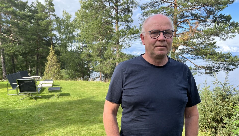 SLEKTSFORSKER: Ole Bjørn Darrud. Bildet viser en voksen mann med briller og lite hår. Han står ute på en gresslette og har på seg blå t-skjorte og lyse bukser. Han har hendene i lommene.