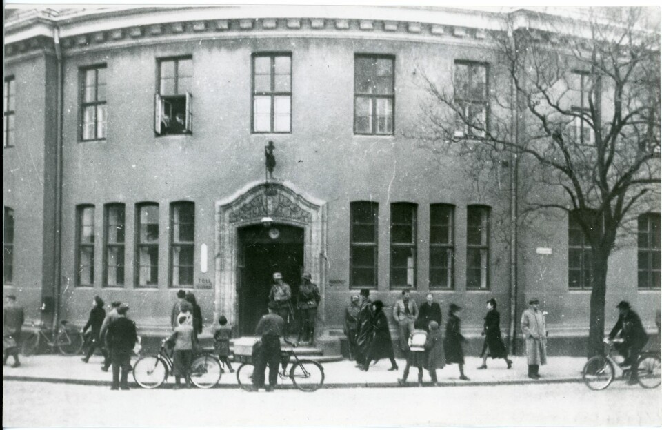 UTENFOR POSTHUSET: Klokken viser 15.00. Datoen er 9. april 1940. Ingen ryggsekker, håndkofferter, e.l. Se karene i vinduet.