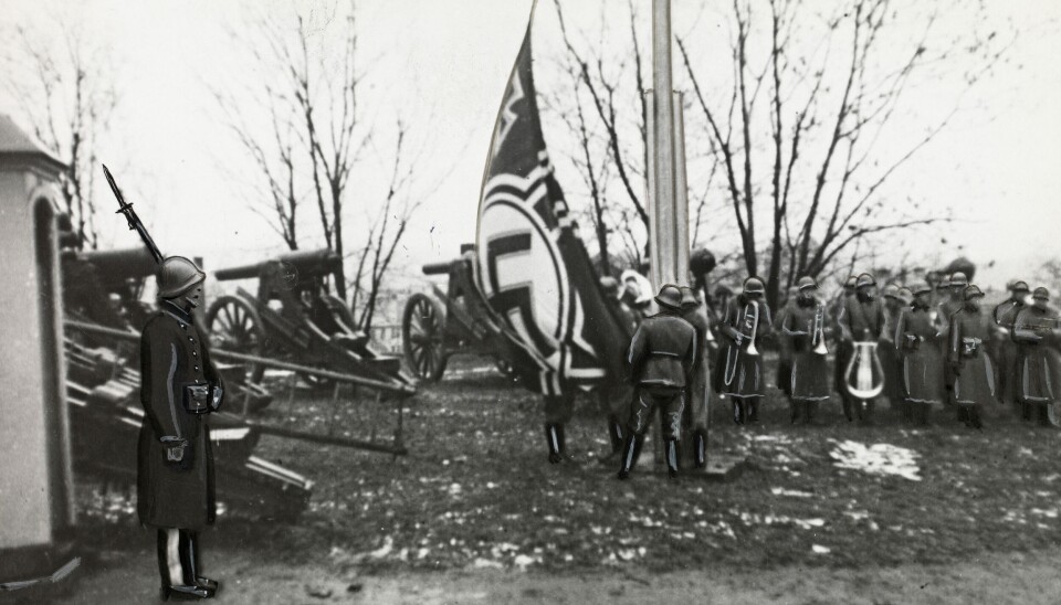 OKKUPERT: Akershus Festning 9. april 1940. Hakekorset heises av tyske soldater. En norsk gardist står fortsatt vakt.