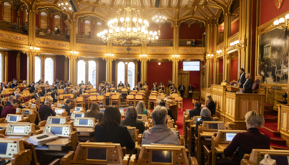 ENDELIG: Gjeldende arkivlov er fra 1992. Nå er det klart for førstegangsbehandling av ny arkivlov i Stortinget. Bildet viser en flott sal med røde vegger, forseggjorte stoler som vender mot et platå med talerstoler. ROmmet har flotte utsmykkinger og en stor forseggjort taklampe midt i rommet.