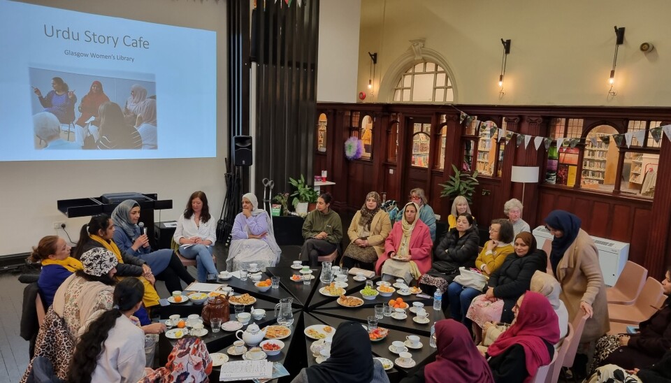 MØTEPLASS: Det var mange rundt bordet da prosjektarbeider Syma Ahmed og bibliotekar Wendy Kirk holdt «Story Cafe» på urdu. Den berømte brune tekannen var selvsagt med. -Det er et tankekors at dette rommet for rundt 100 år siden var en lesesal kun for menn, sier Kirk nå.