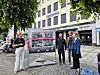Fire personer ser på en utstillingstavle foran Agderposten